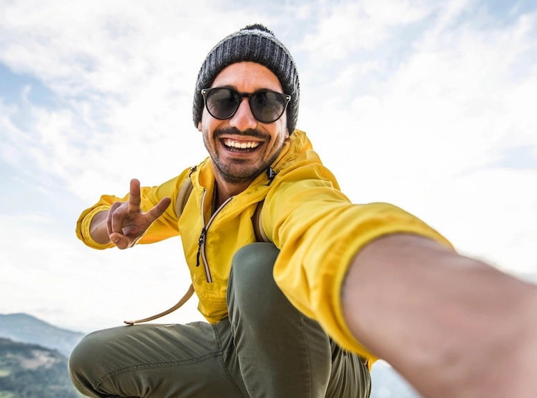 happy hiker taking a selfie on tops of a mountain