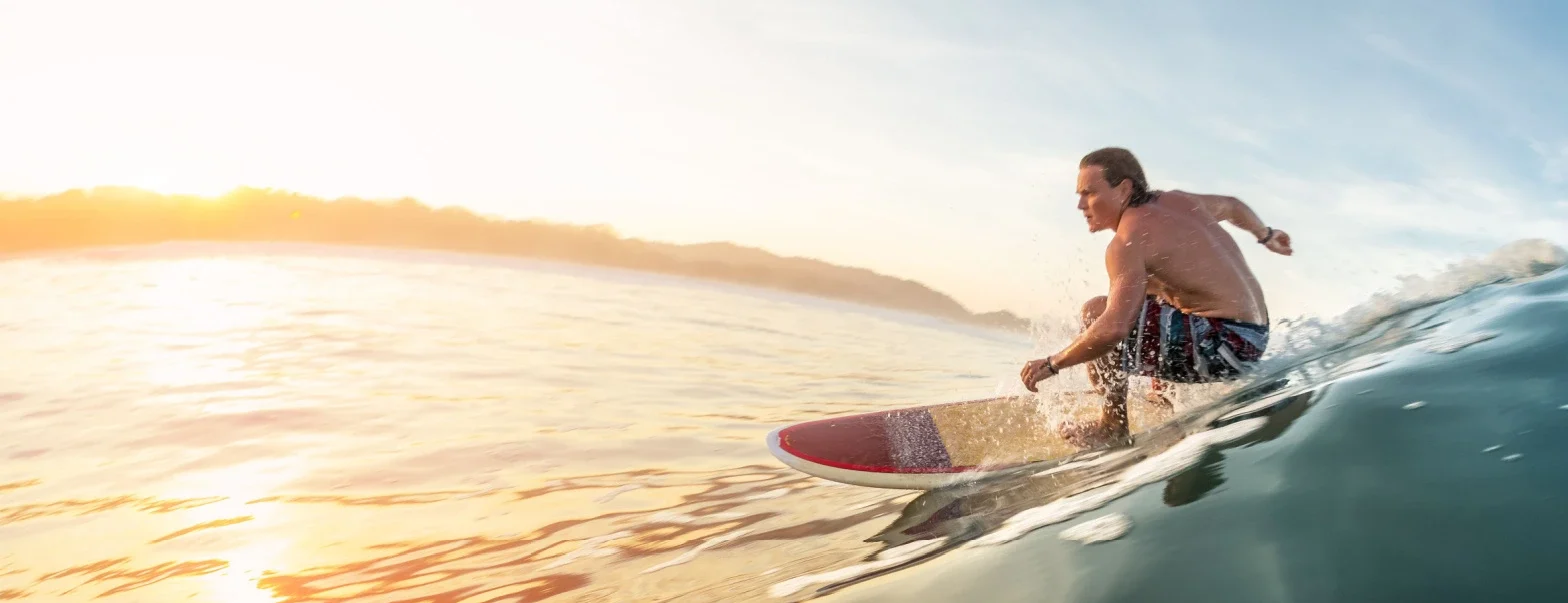 Surfer riding a wave at sunset