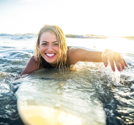 young woman surfing and smiling