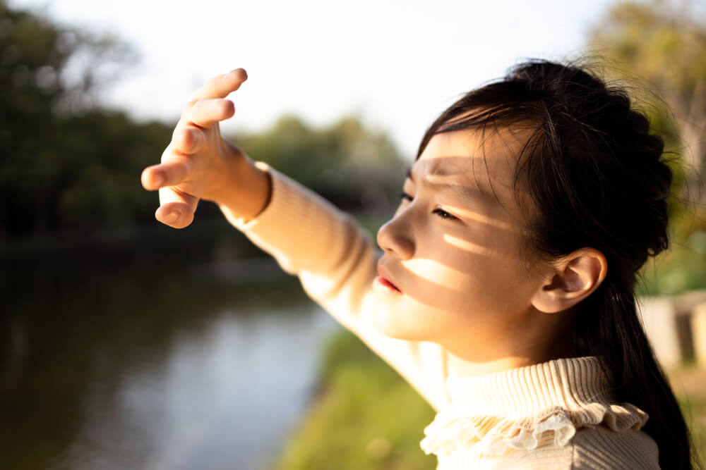 Girl Covering Face by Hand to Protect Face From Bright Sun